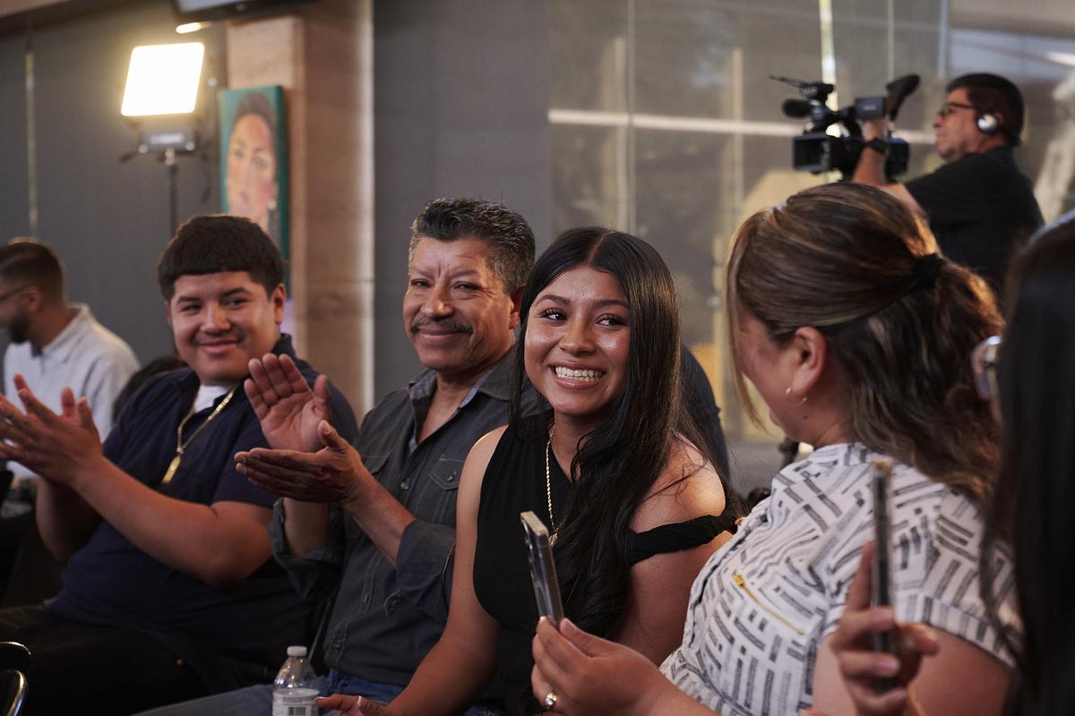 Itzel Perez Lillos smiles wearing a black dress after being announced the Univision scholarship winner