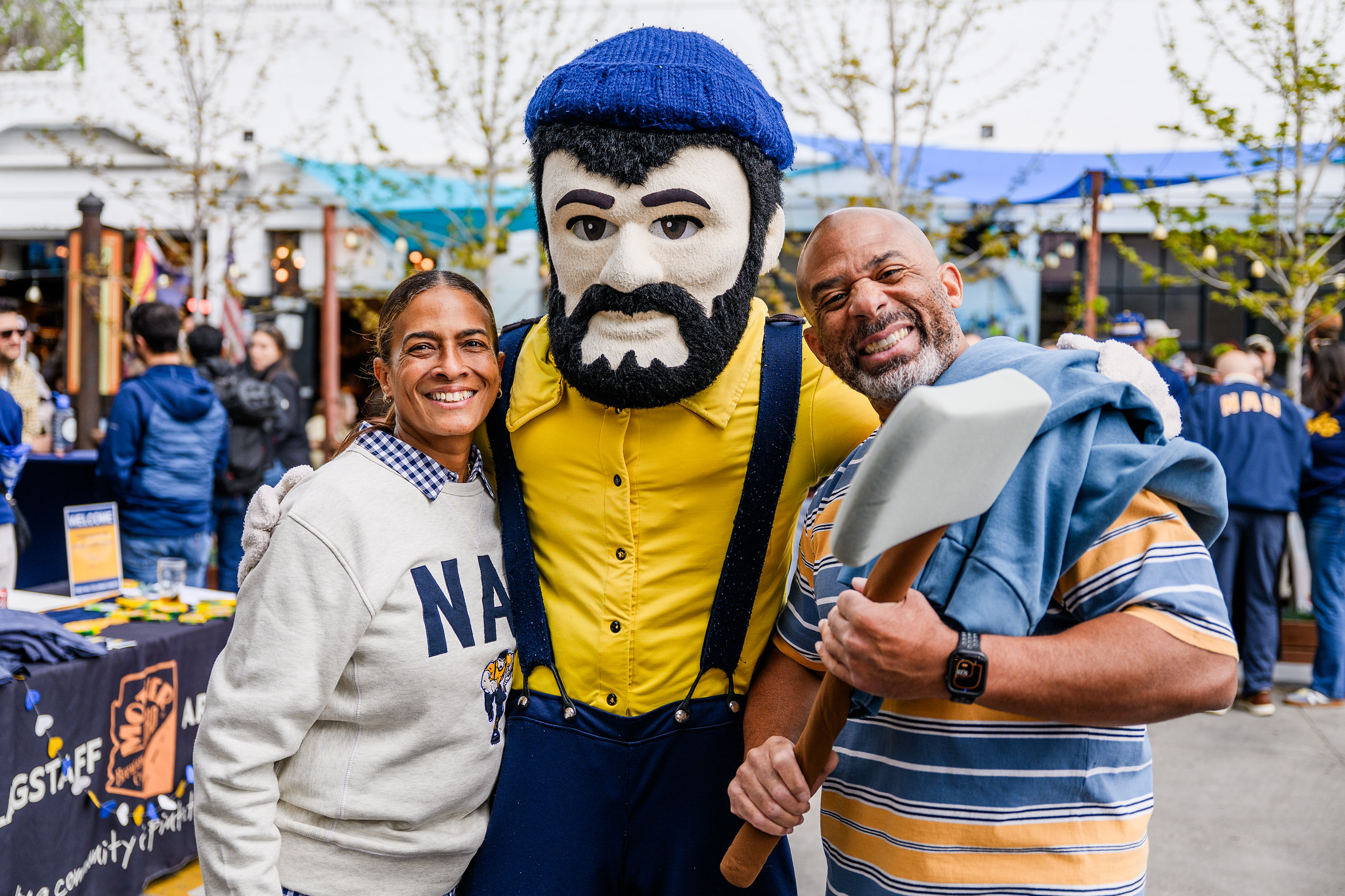 Regina Webster and husband John Brown pose with Louie the Lumberjack for NAU Giving Day 2026